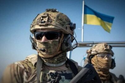 Сучасний український бронежилет чорного кольору на фоні державного прапора