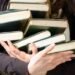 Людина вчиться скороченню тексту за допомогою нотаток та книги