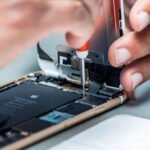 Фахівець у сервісному центрі Apple ремонтує iPhone