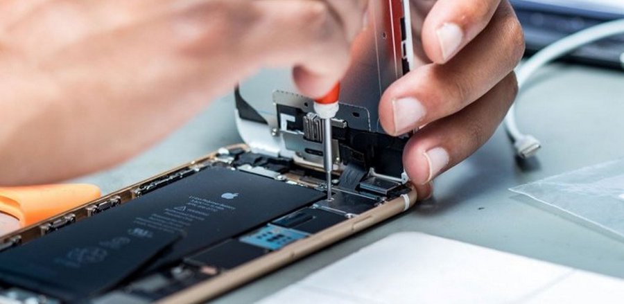 Фахівець у сервісному центрі Apple ремонтує iPhone